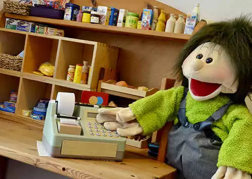Kaufmannsladen mit Kasse und Puppe